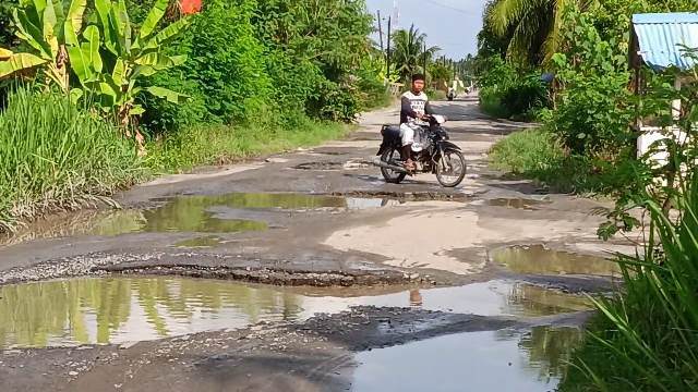 Teks foto: Badan Jalan di Desa Gelam Sei Serimah Kecamatan Bandar Khalipah, Serdang Bedagai mirip dengan "Kolam ikan"